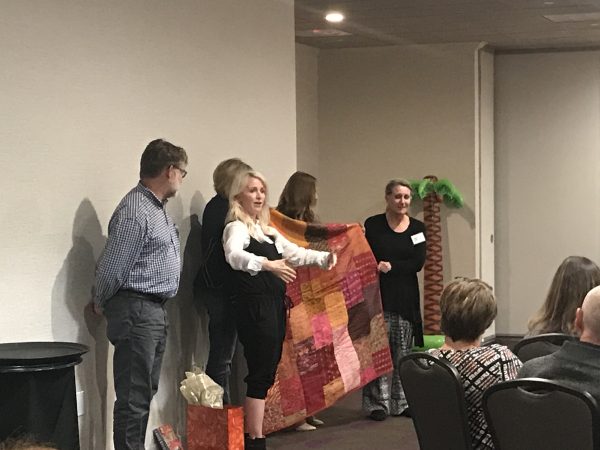 Core graduates present their group leader with a blanket made of patchwork saris.